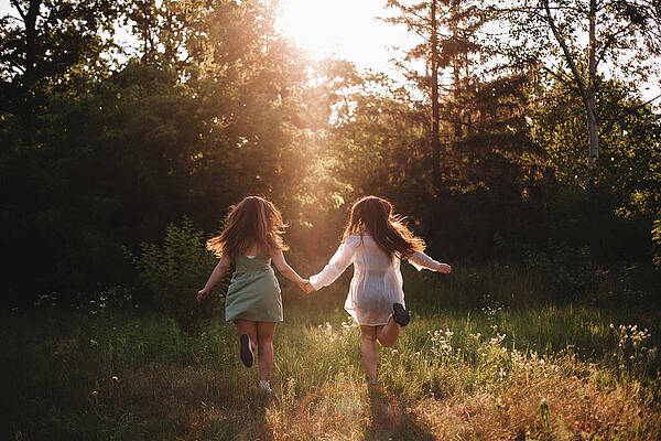 Wall Art - Photograph - Back View Of Girlfriends Holding Hands While Running In Summer Forest #1 by Cavan Images