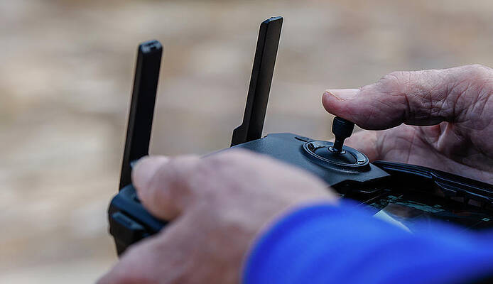 Wall Art - Photograph - Close-up Of Old Man Operating Drone Using A Remote Control #1 by Cavan Images