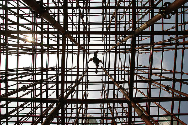 Wall Art - Photograph - A Labourer Walks Across Scaffolding by Stringer Shanghai