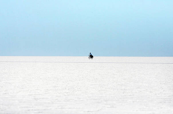 Wall Art - Photograph - A Man Rides a Bicycle on the Surface by Jorge Silva