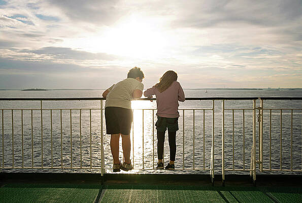 Wall Art - Photograph - Boy And Girl With Backs To Camera Looking At Ocean From A Ferry by Cavan Images