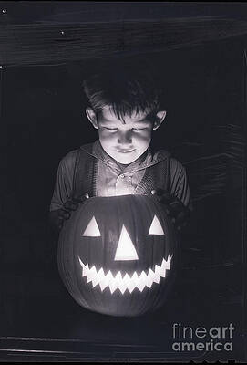 Wall Art - Photograph - Boy Looking Into Jack Olantern by Bettmann
