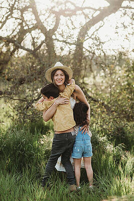 Wall Art - Photograph - Full Length View Of Mother Hugging Son And Daughter In Backlit Field by Cavan Images