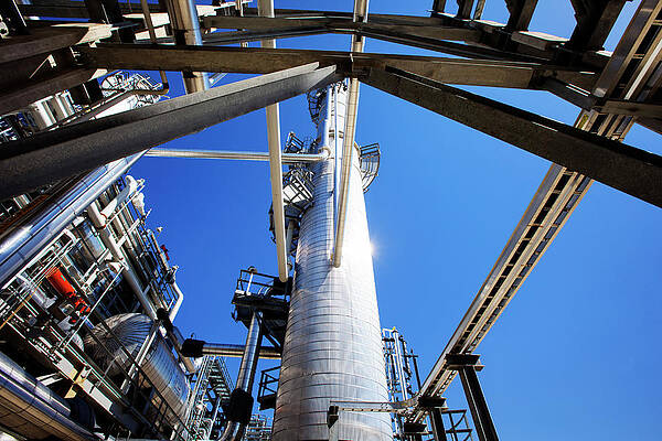 Wall Art - Photograph - Low Angle View Of Pipelines And Chimney At Power Station Against Clear Sky by Cavan Images