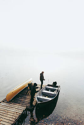 Wall Art - Photograph - Man And Child Getting Ready To Go Fishing In A Boat On A Foggy Day. by Cavan Images