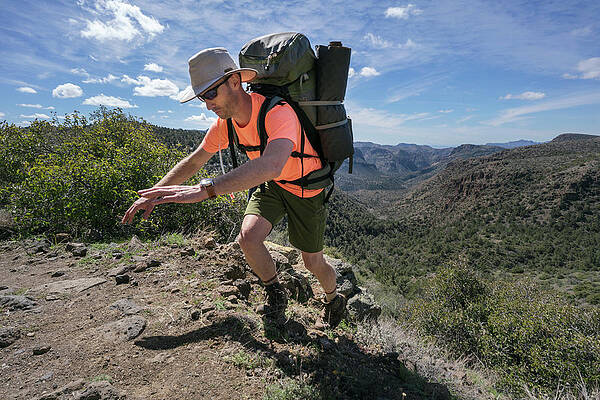 Wall Art - Photograph - Man Balancing As He Hikes Up Trail, Mountain Views In Background by Cavan Images