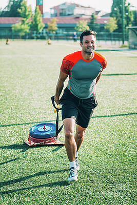 Wall Art - Photograph - Man Dragging A Tyre by Science Photo Library