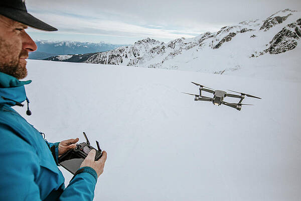 Wall Art - Photograph - Man Operates Drone On Snow Covered Mountain. by Cavan Images