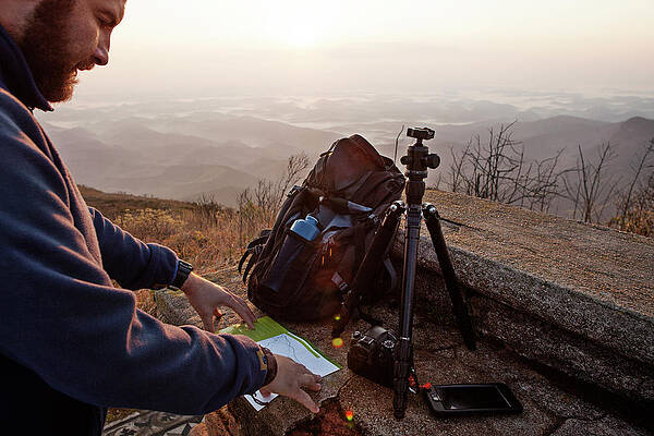 Wall Art - Photograph - Man Reading At Map While Standing On Mountain During Sunset by Cavan Images