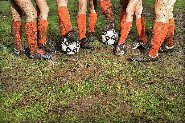 Muddy Legs Of Soccer Players Print by Jupiterimages