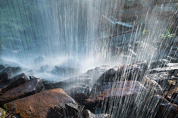 Wall Art - Photograph - Shot From Behind Waterfall Crashing On Rocks Backlit Abstract by Cavan Images