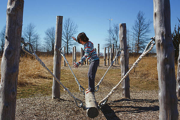 Wall Art - Photograph - Side View Of A Barefoot Child Balancing On A Log In Obstacle Course by Cavan Images