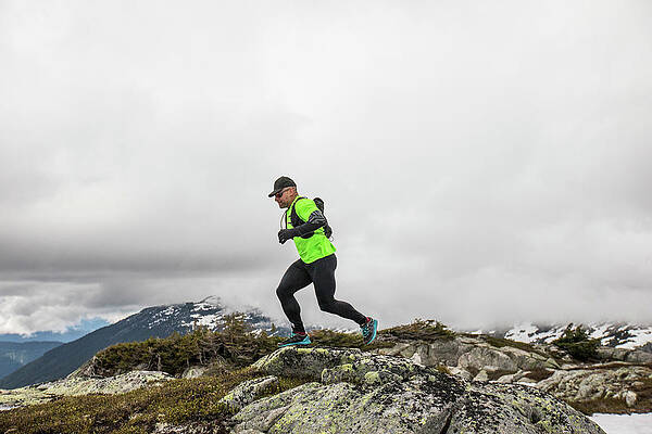 Wall Art - Photograph - Side View Of Fit Active Man Trail Running On Mountain Ridge. by Cavan Images