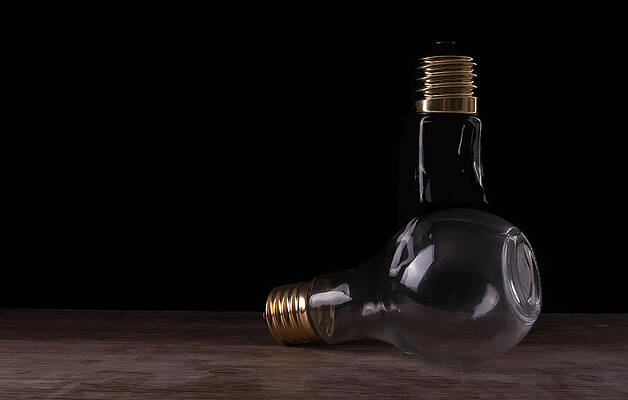 Two light bulbs arranged on a wooden table by Vincent Billotto Two light bulbs arranged on a wooden table by Vincent Billotto