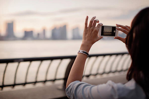 Wall Art - Photograph - Woman Photographing City Skyline During Sunset by Cavan Images