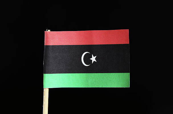 Wall Art - Photograph - A official flag of Libya on toothpick on black background. Consists of a horizontal triband of red, black and green with screscent and white star centred on the black stripe by Vaclav Sonnek