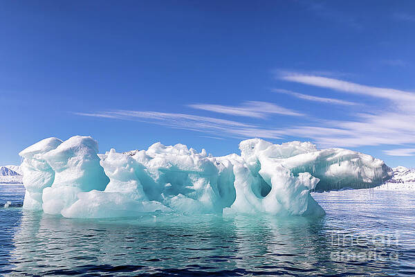 Blue ice iceberg, formed when a glacier calves, floating in the arctic waters of Svalbard, Arctic Circle by Jane Rix Blue ice iceberg, formed when a glacier calves, floating in the arctic waters of Svalbard, Arctic Circle by Jane Rix