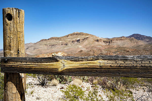 Fence post and desert mountains by Craig Daugherty