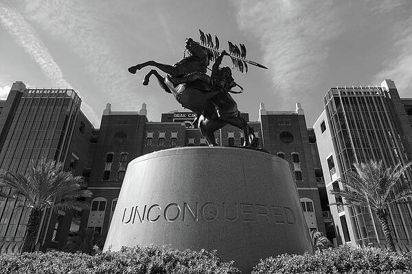 Wall Art - Photograph - Unconquered statue in front of Doak Campbell Stadium at Florida State University in black and white by Eldon McGraw