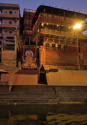 Wall Art - Photograph - Varanasi, India Bunch of wooden boat docked in ganges river next to empty ghat and ancient building before sunrise in state of Uttar Pradesh. Hindu holy place with ganesh image by Arpan Bhatia