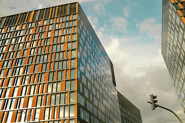 Wall Art - Photograph - Wide angle view of modern corporate office building architecture with glass and metallic construction with reflection against blue clouds located in Lodz, Poland by Arpan Bhatia
