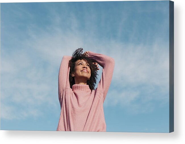 Hands Behind Head Acrylic Print featuring the photograph Portrait of happy young woman enjoying sunlight #1 by Westend61