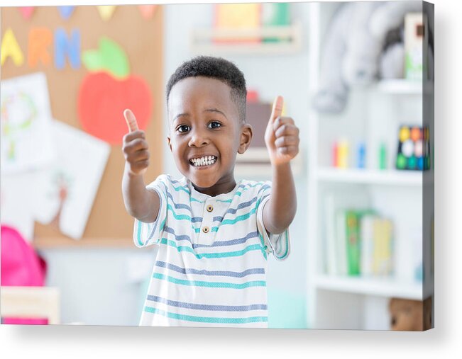 Toddler Acrylic Print featuring the photograph Adorable boy gives thumbs up in preschool by Asiseeit