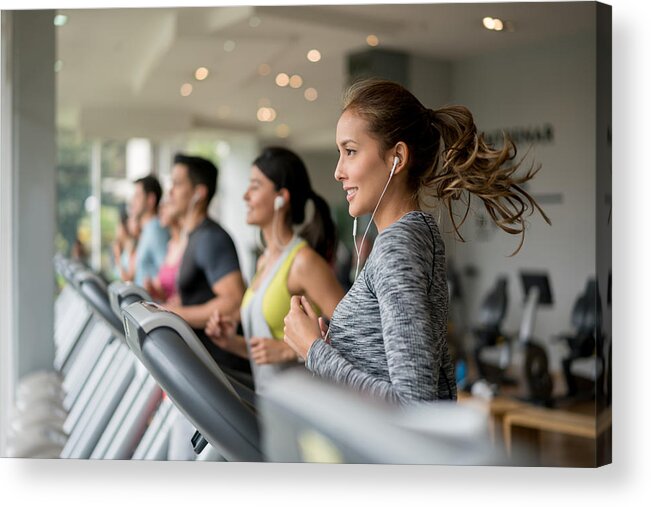 Young Men Acrylic Print featuring the photograph Beautiful woman exercising at the gym running on a treadmill by Andresr