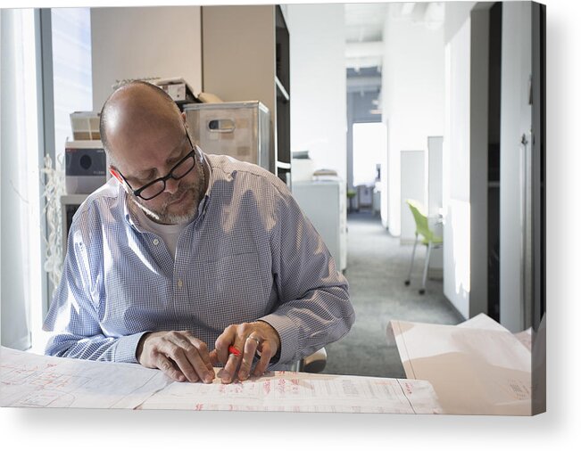 Working Acrylic Print featuring the photograph Businessman sketching blueprints in office by Hill Street Studios
