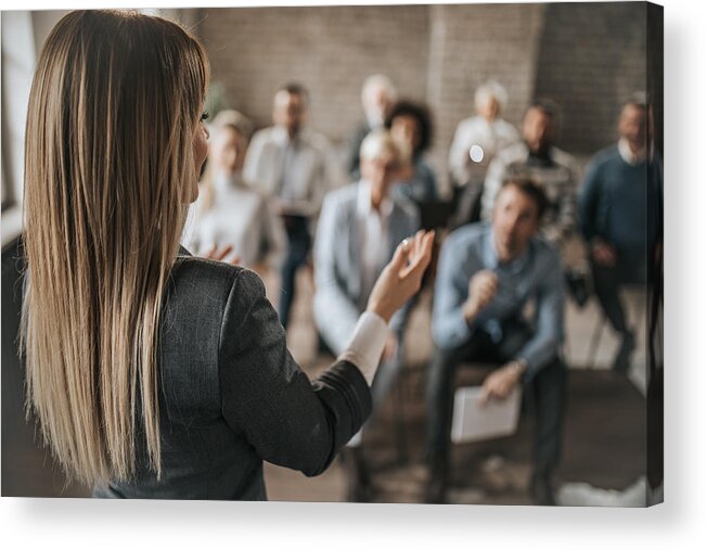 New Business Acrylic Print featuring the photograph Female manager talking to large group of her colleagues on a business seminar. by Skynesher