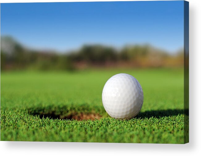 Putting Green Acrylic Print featuring the photograph Ground level close up of golf ball close to hole by PhotoTalk