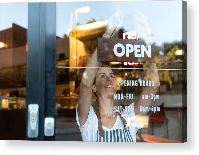New Business Acrylic Print featuring the photograph Happy business owner hanging an open sign at a cafe by Andresr