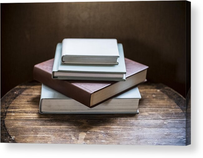 England Acrylic Print featuring the photograph High angle close up of stack of book s on wooden table. by Mint Images