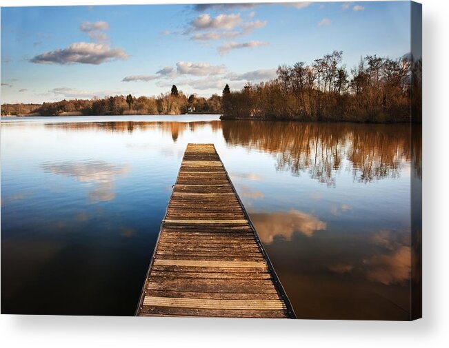 Pier Acrylic Print featuring the photograph Landscape of fishing jetty on calm lake at sunset with reflectio by Matthew Gibson