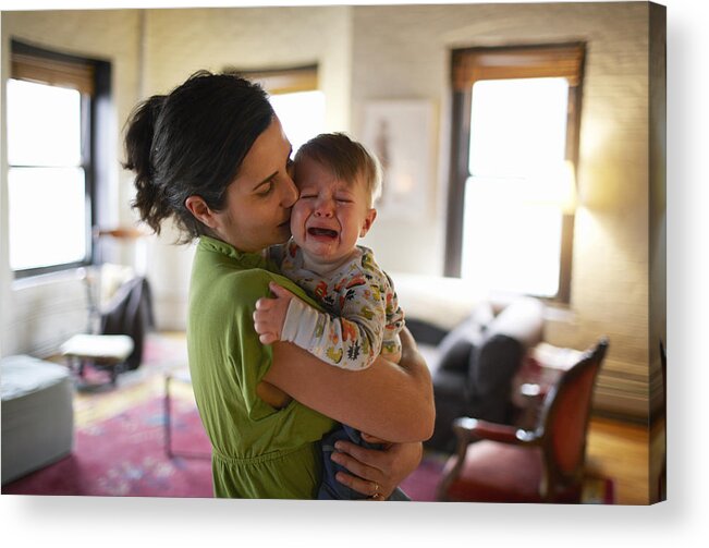 Three Quarter Length Acrylic Print featuring the photograph Mother holding and kissing crying baby boy (12-17 months) (focus on foreground) by Ben Bloom
