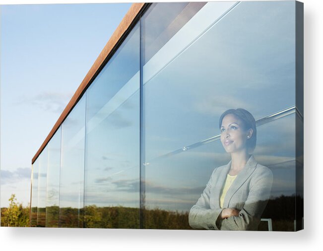 Corporate Business Acrylic Print featuring the photograph Pensive businesswoman with arms crossed in office window by Martin Barraud