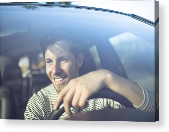 Young Men Acrylic Print featuring the photograph Smiling young man driving car by Westend61