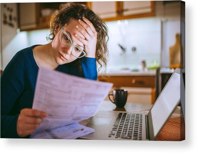 Debt Acrylic Print featuring the photograph Woman going through bills, looking worried by Urbazon