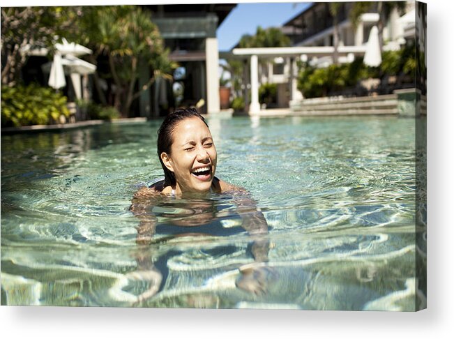 Asian And Indian Ethnicities Acrylic Print featuring the photograph Woman laughing and swimming at luxury resort by Wander Women Collective