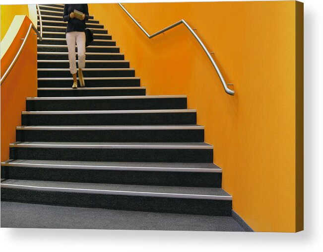 Cool Attitude Acrylic Print featuring the photograph Young woman walking down orange stairs, reading book by B&M Noskowski