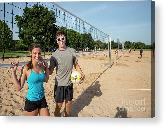 Zilker Park Beach Volleyball Courts Acrylic Print featuring the photograph Young fit couple on the at the Zilker Park sand volleyball courts with volleyball on sunny summers day #2 by Dan Herron