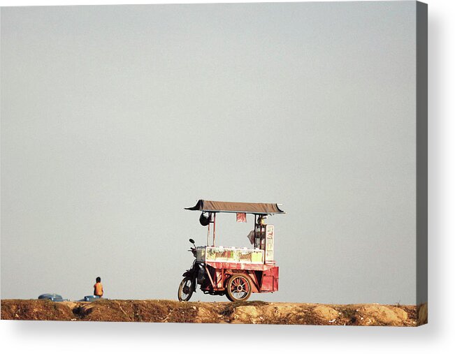 Child Acrylic Print featuring the photograph A Boy Vendor Sits On The Bank Of Tonle by © Daniel Yao