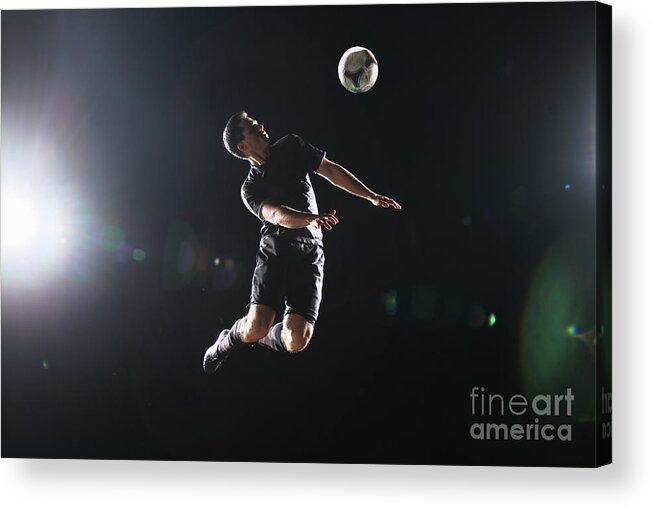 Soccer Uniform Acrylic Print featuring the photograph Soccer Player Jumping To Ball On Dark by Stanislaw Pytel
