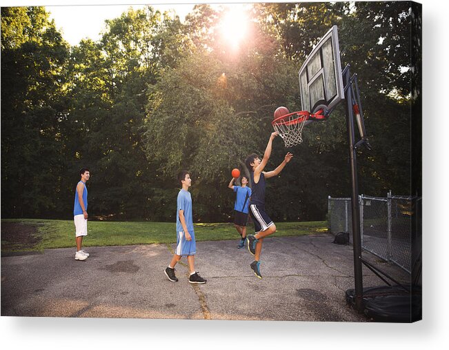 Young Men Acrylic Print featuring the photograph Players playing basketball at court against trees on sunny day #1 by Cavan Images