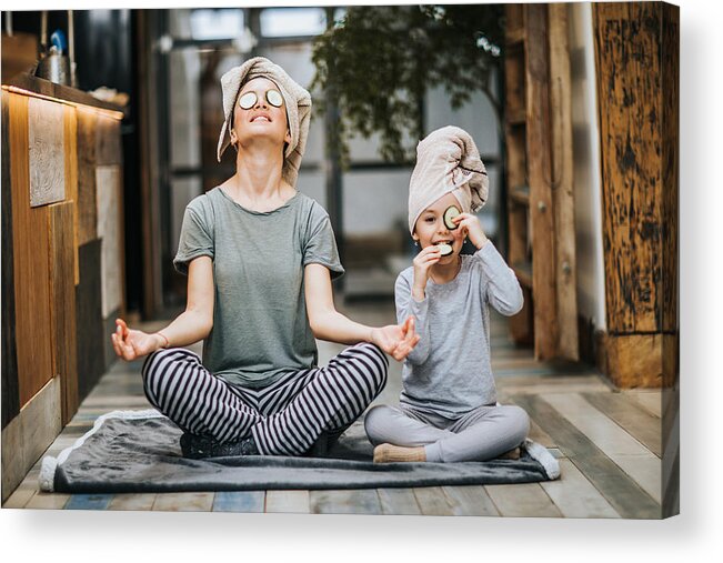 Child Acrylic Print featuring the photograph Relaxed mother and daughter exercising Yoga in the morning at home. by Skynesher
