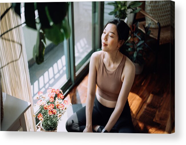 Tranquility Acrylic Print featuring the photograph Active young Asian sports woman taking a break after working out at home, sitting on exercise mat taking a deep breath with her eyes closed. Sports and exercise routine. Health, fitness and wellness concept by D3sign