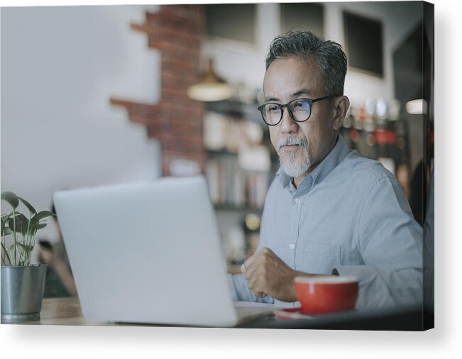 One Man Only Acrylic Print featuring the photograph An Asian Chinese Senior Man Having Discussion With His Colleague Via Online Virtual Meeting In A Cafe by Edwin Tan