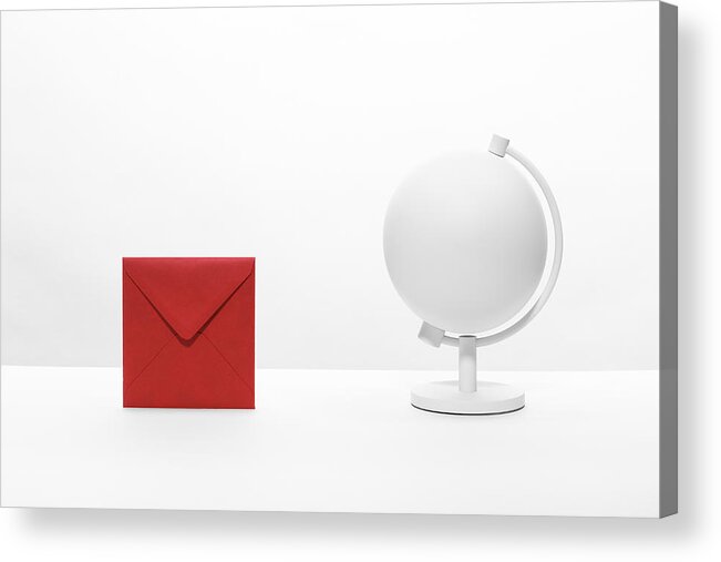 Empty Acrylic Print featuring the photograph An envelope on a desktop next to a desk globe by Creative Crop