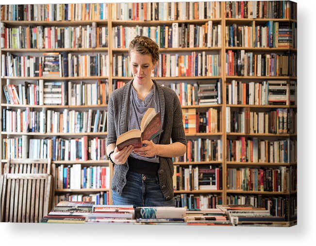 Three Quarter Length Acrylic Print featuring the photograph Beautiful young female customer reading book at bookstore by Luis Alvarez