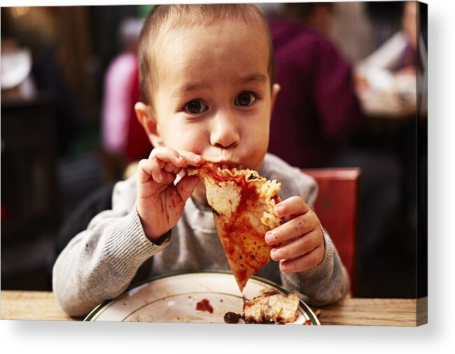 Toddler Acrylic Print featuring the photograph Boy eating pizza in restaurant by Jpm